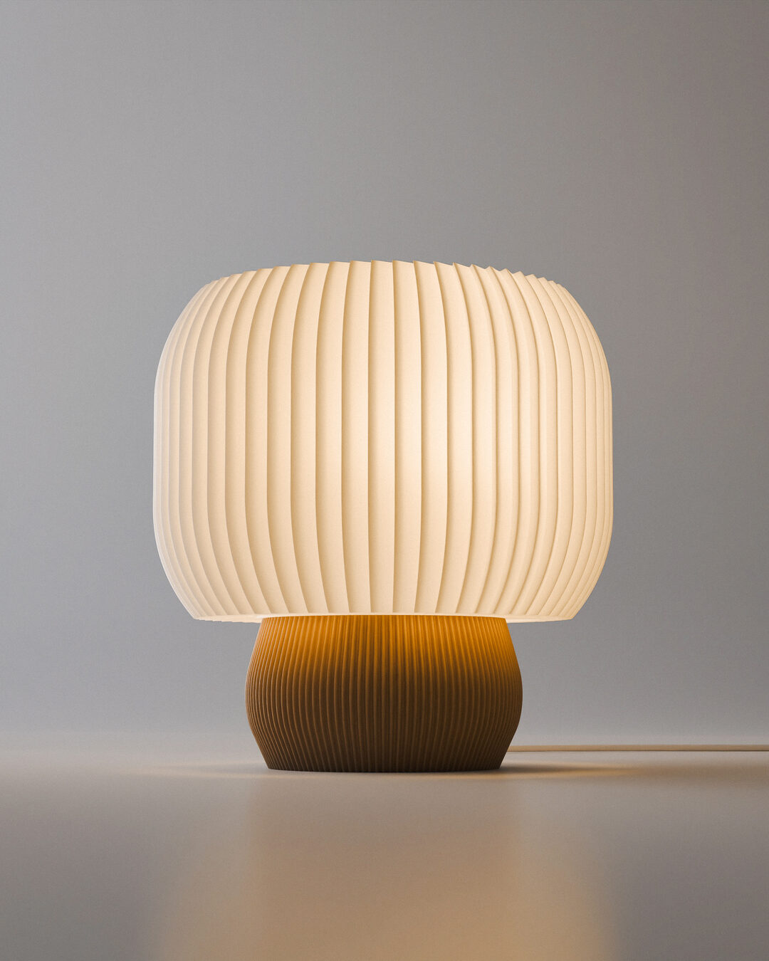 Luminária Selene acesa, cúpula plissada em tambor com base caramelo iluminada